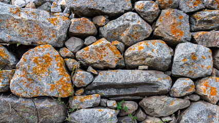 background of ancient stones stacked in the wall exposed to external natural factors. copy space.