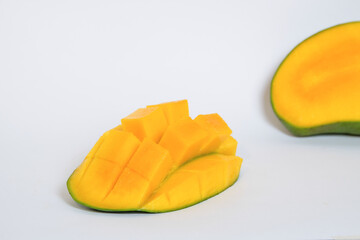 Yellow ripe mango slices isolated on white background.Copy space for text.Source of vitamin c.Fresh fruit concept.Mango sliced in squares.For graphic design or banner background