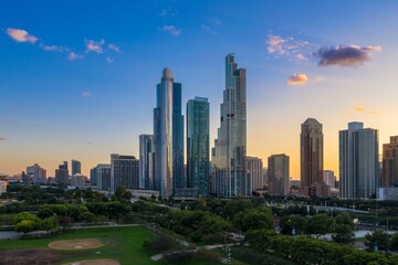 Fototapeta premium Chicago skyline at sunset, viewed from Millennium Park. Modern high-rises contrast with parkland. Beautiful city scene. Grant Park, Chicago, Illinois, United States