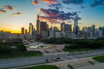 Chicago skyline at sunset, viewed from above, with Buckingham Fountain in the foreground. City traffic and park goers. Clarence F. Buckingham Memorial Fountain, Chicago, Illinois, United States
