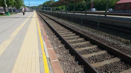 Walk on a platform along railways at Kaunas train station, in Kaunas, Lithuania on a sunny day