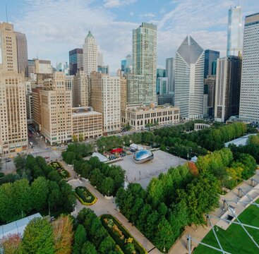 Chicago skyline and Millennium Park. Cloudless day, people enjoying the park. Iconic Bean sculpture. Millennium Park, Chicago, Illinois, United States