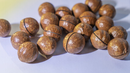 A top view of a bunch of macadamia nuts resting on a uniform background, showcasing their rich texture and natural color. Perfect for food-related designs and healthy snack concepts.