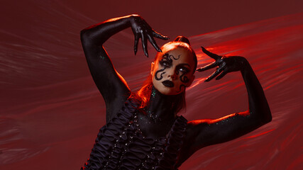 Snake-like, stylish and daring woman, make-up with a snake pattern, bright photo on a red...