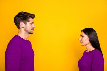 Profile side photo of concentared man and woman stare face-to face wear red pullover isolated over yellow background