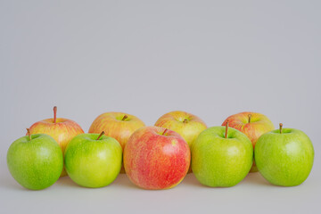 Green and red apples on a gray background. Fruits, apples