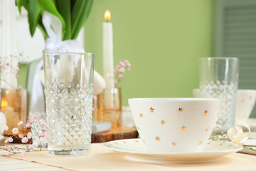 Beautiful table setting for International Women's Day celebration near green wall