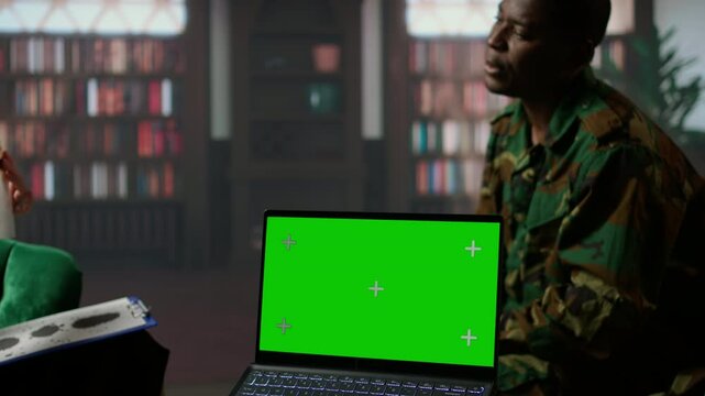 Military trooper studies Rorschach inkblot illustration next to green screen in therapy with psychologist, addressing PTSD and trauma recovery problems. Psychological support. Camera A.