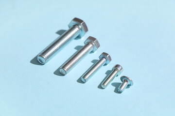 Row of different tap bolts on blue background