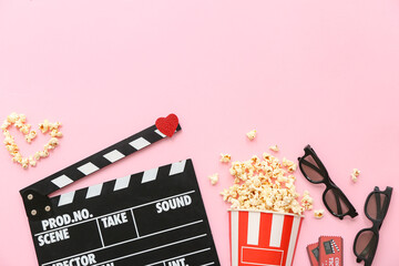 Bucket of popcorn with cinema tickets, movie clapper and 3D glasses on pink background. Valentine's...