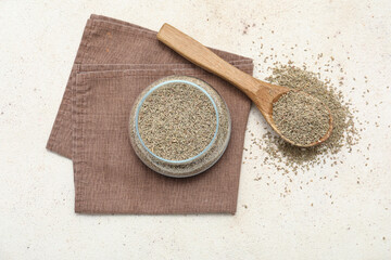 Jar of dried anise seeds and wooden spoon on light background