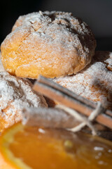 orange cookies and cinnamon powdered sugar on black background kitchen concept