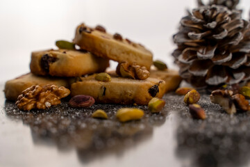 Pine nut cookies on black and white background with pine cones next to them kitchen concept