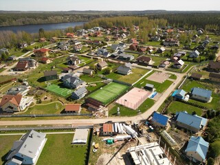 Enjoy a scenic aerial view of a suburban neighborhood with tennis courts and greenery