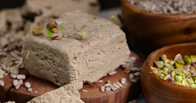 halva from roasted sunflower seeds closeup, a sweet delicious dessert made from fried sunflower seeds with pistachios, wooden bowl