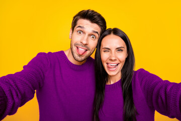 Fototapeta premium Close up photo of cheerful spouses grimace take self portrait wear red sweater isolated over yellow background