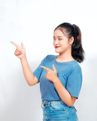 Excited Asian woman pointing at the copy space beside her, isolated on white background