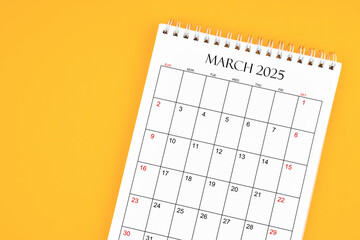 March 2025 desk calendar on yellow color background, position with copy space.