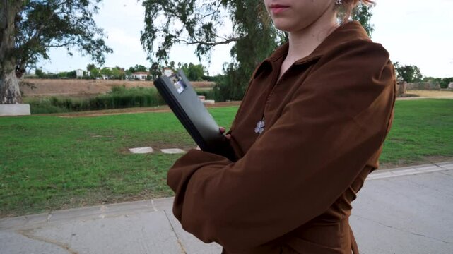 Chica joven atravesando un parque de camino al instituto o la universidad.