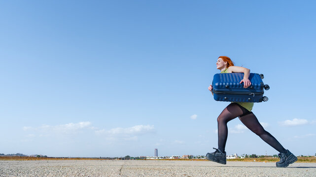 Mujer viajera corriendo con mucho deseo hacia el espacio para texto como concepto de oferta, rebaja o algo que es muy bueno, un d&iacute;a soleado con cielo azul en una pistas de aterrizaje.