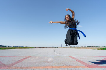 Chica luchadora de artes marciales saltando muy contenta con los brazos abiertos y una sonrisa una...
