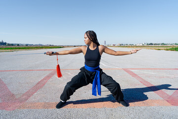 Chica joven luchadora de artes marciales en el paisaje infinito y minimalista de una pista de...