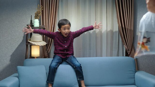 Little boy excitedly received the gift of beautiful pet fish inside. A joyful surprise that brings warmth to home. Pet fish, gift, surprise, family, joy