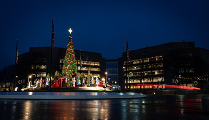 Belleville, Illinois, USA - December 28, 2024: A Christmas tree and decorations display in front of the St. Clair County Circuit Clerk's office, with the taillights of early morning traffic.