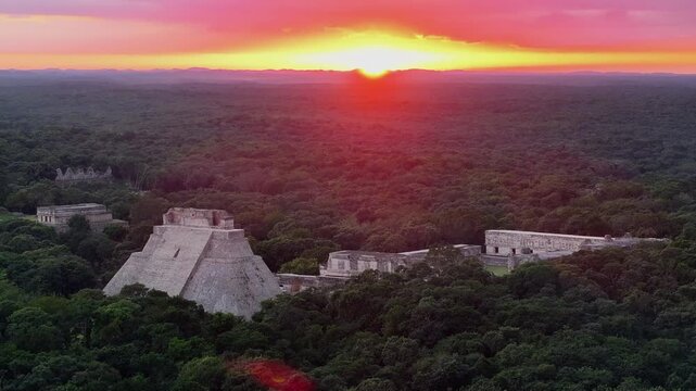 Aerial establishing orbit of the ancient Mayan city of Uxmal during a vibrant sunset in Yucatan, Mexico