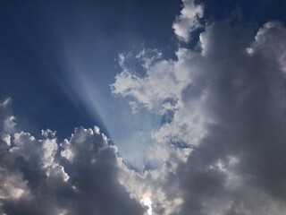 blue sky with sun rays in the clouds