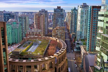 A stunning view of downtown Vancouver showcasing modern high-rise buildings and a unique green...