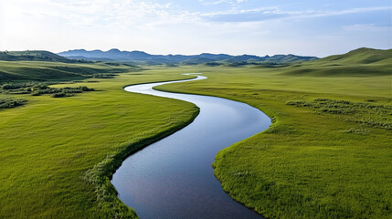 Serene river winding through lush green fields under clear sky