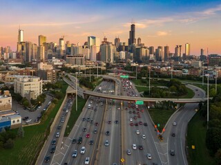 Chicago's highway system at sunset, showing heavy traffic flow and city skyline. Vehicles navigate the complex highway network. Interstate 90, Chicago, Illinois, United States