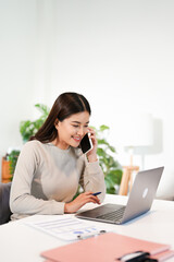 Asian business woman making a phone call and smiling indoor
