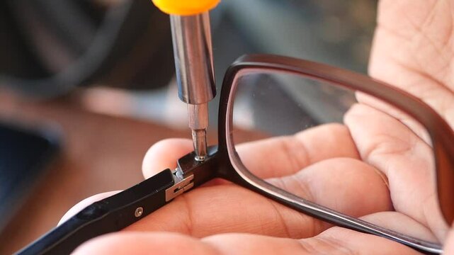 Repairing Eyeglasses A Detailed CloseUp of Skilled Hands at Work on Vintage Eyewear Pieces