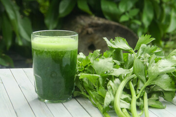 Celery juice, healthy green drink made from celery, green celery smoothie decorated with fresh green celery leaves