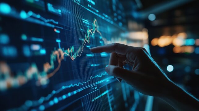 Close-up of hands pointing to a data point on a graph on a large dashboard monitor.