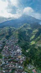 Colorful houses dot the slopes of Mount Sumbing, creating a vibrant and picturesque scene. Known as Nepal van Java, the hillside village radiates charm against a majestic mountain backdrop.