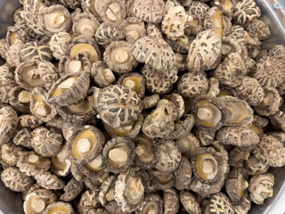 A top down view of a pile of dried shiitake mushrooms, on display at a local grocery store.