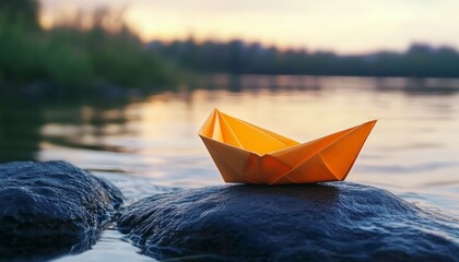 Fototapeta premium a beautiful paper boat on a stone near water