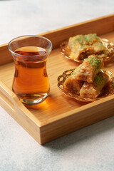 Traditional dessert served with tea on a wooden tray in a cozy setting with soft lighting