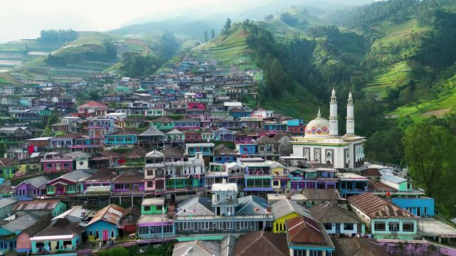 Colorful houses dot the slopes of Mount Sumbing, creating a vibrant and picturesque scene. Known as Nepal van Java, the hillside village radiates charm against a majestic mountain backdrop.