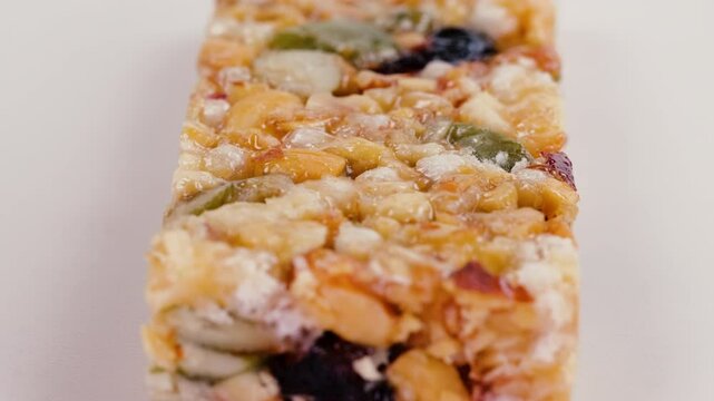 A delicious nut bar, with a  mix of grains, fruits, and nuts. Slider shot. Depth of field, selective focus. Organic and wholesome foods, granola bar, candies, sweet treats, snacks, concepts. 4k