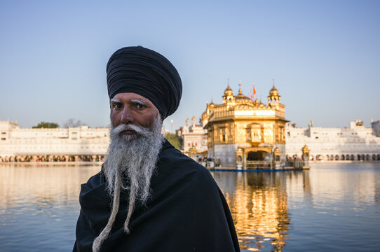 Old sikh man with traditional dress at the golden temple, India