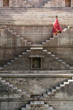Indian woman wearing traditional saree on a staircase inside a stepwell, Jodhpur, Rajasthan, India