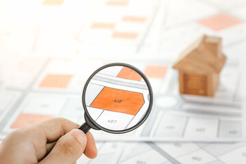 Man holding magnifier on cadastre map search for assesses to buy the land lands. real estate...