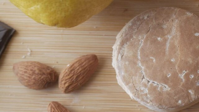 Traditional Spanish Christmas sweet polvoron with almonds, dark chocolate, lemon, and a rustic wooden background.