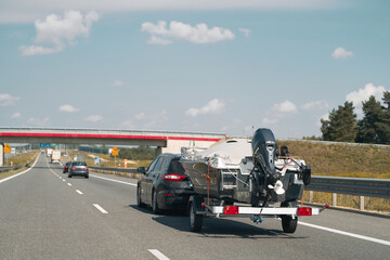 Vehicle with boat trailer driving on road