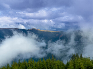 Winter scenery in the Transylvanian Alps with mist and storm clouds