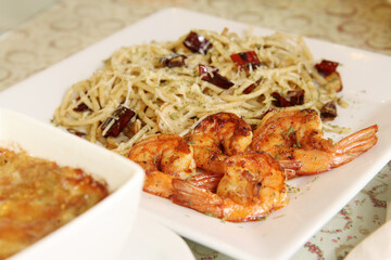 Spaghetti stir-fried with chili, garlic and grilled shrimp, fusion Thai food, selective focus, close-up
